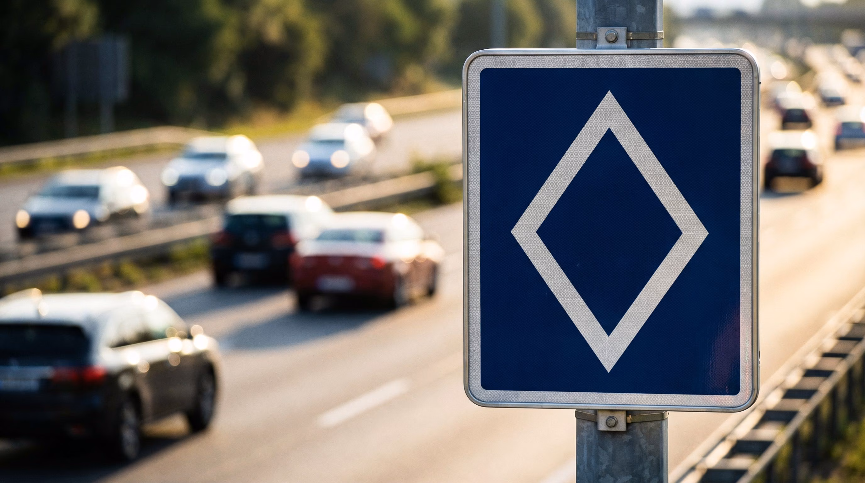 What does the new road sign with a white diamond indicate and in which countries it is used